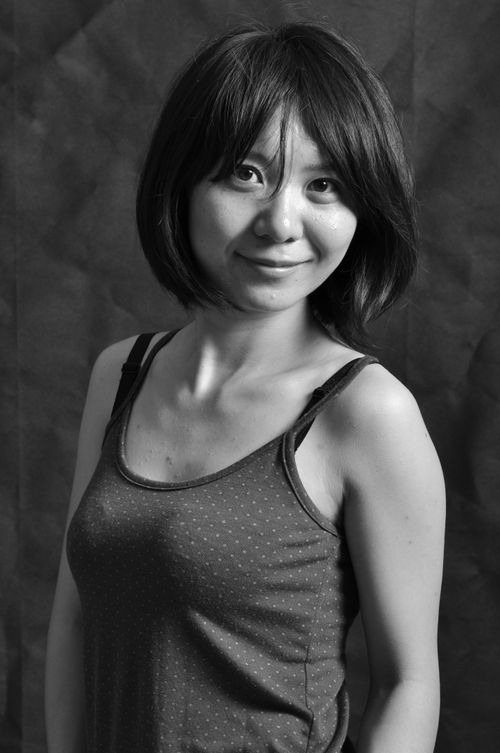 Free Artistic black and white portrait of a woman smiling against a textured background. Stock Photo