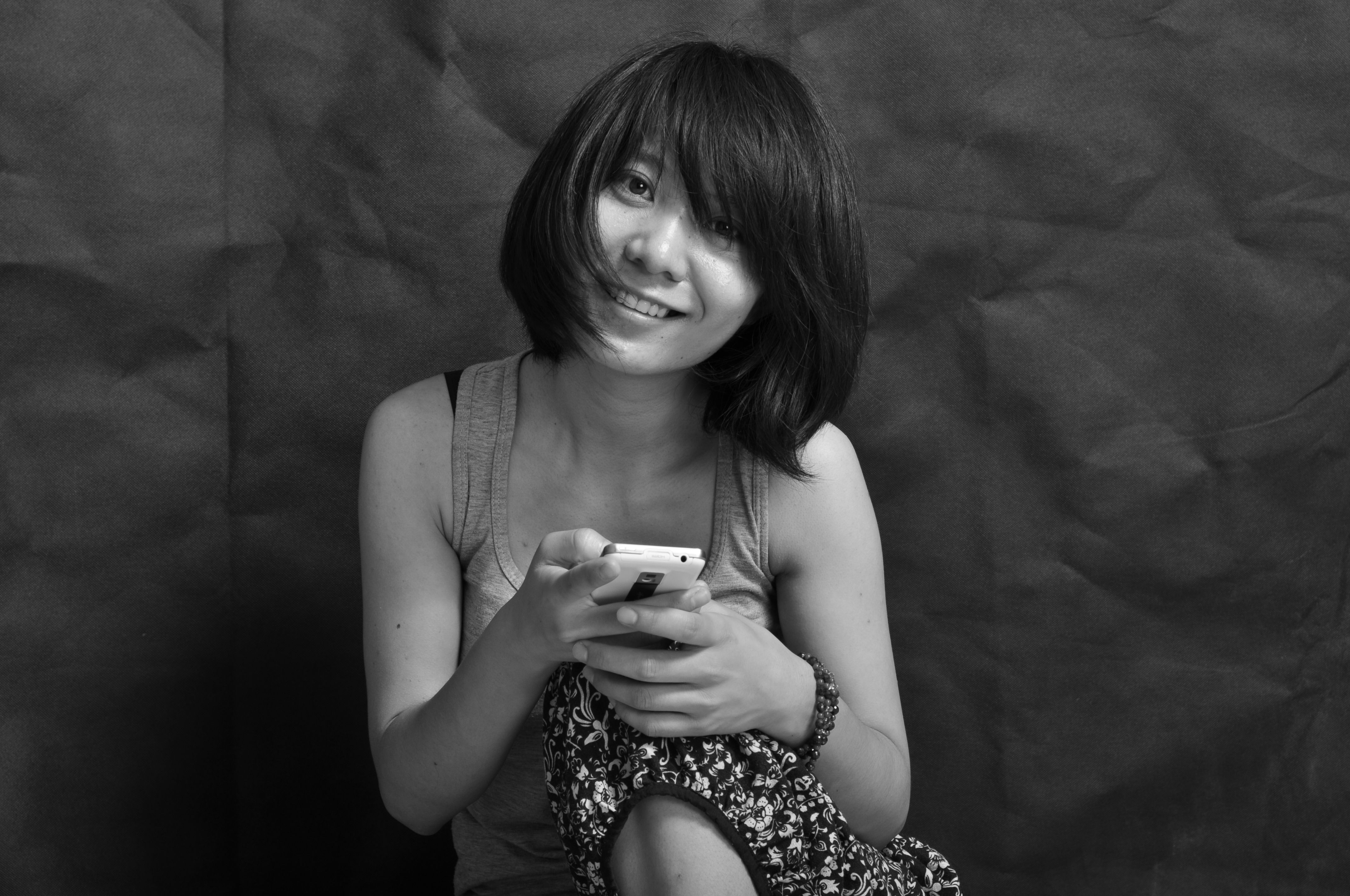 Black and White Portrait of a Smiling Woman with Smartphone