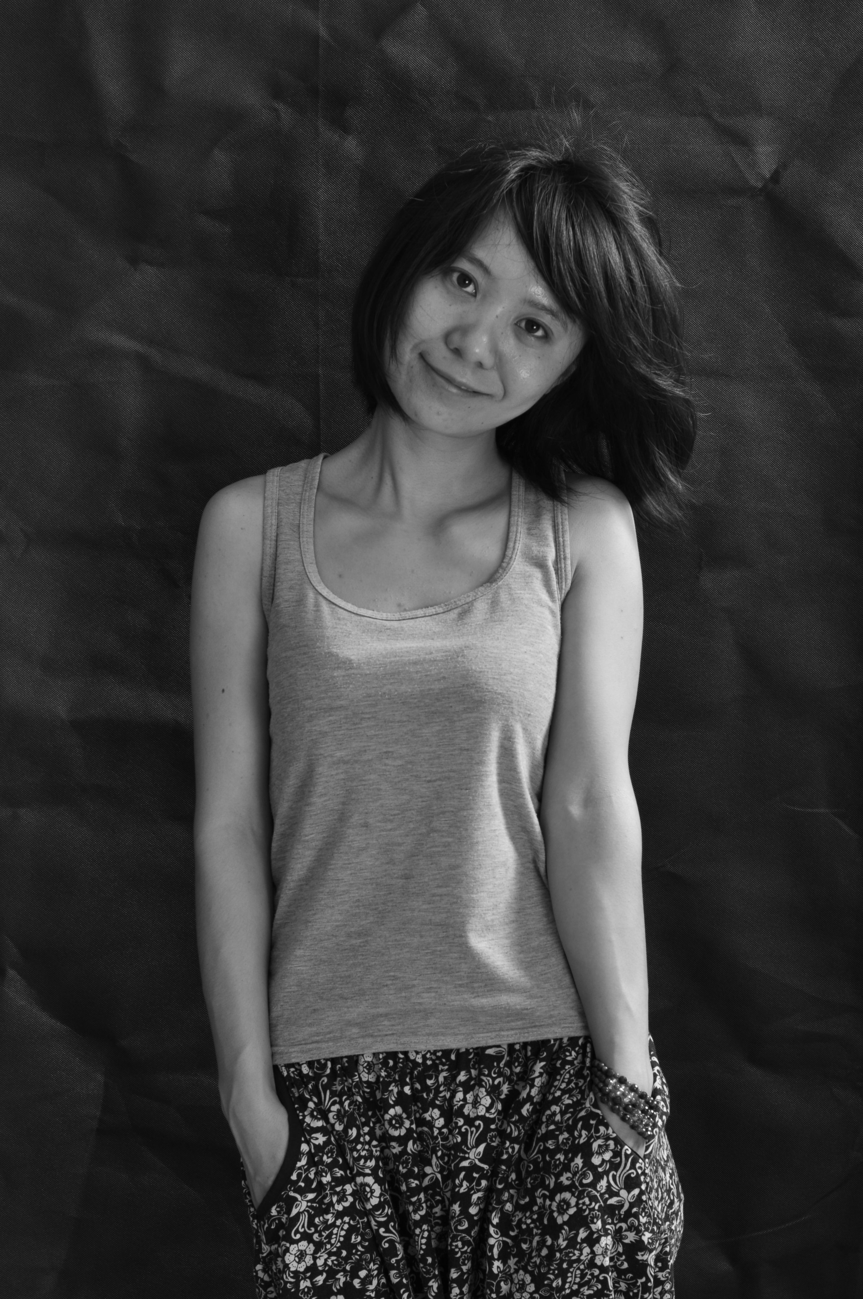 Captivating black and white portrait of a smiling woman in casual attire.
