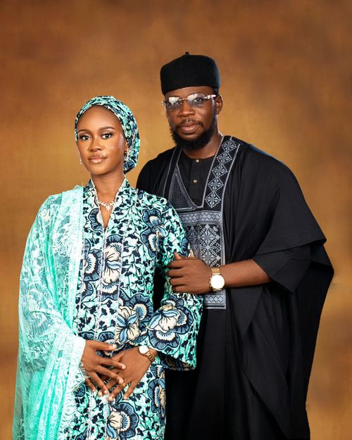 Free A stylish Nigerian couple in traditional clothing posing against a warm backdrop. Stock Photo