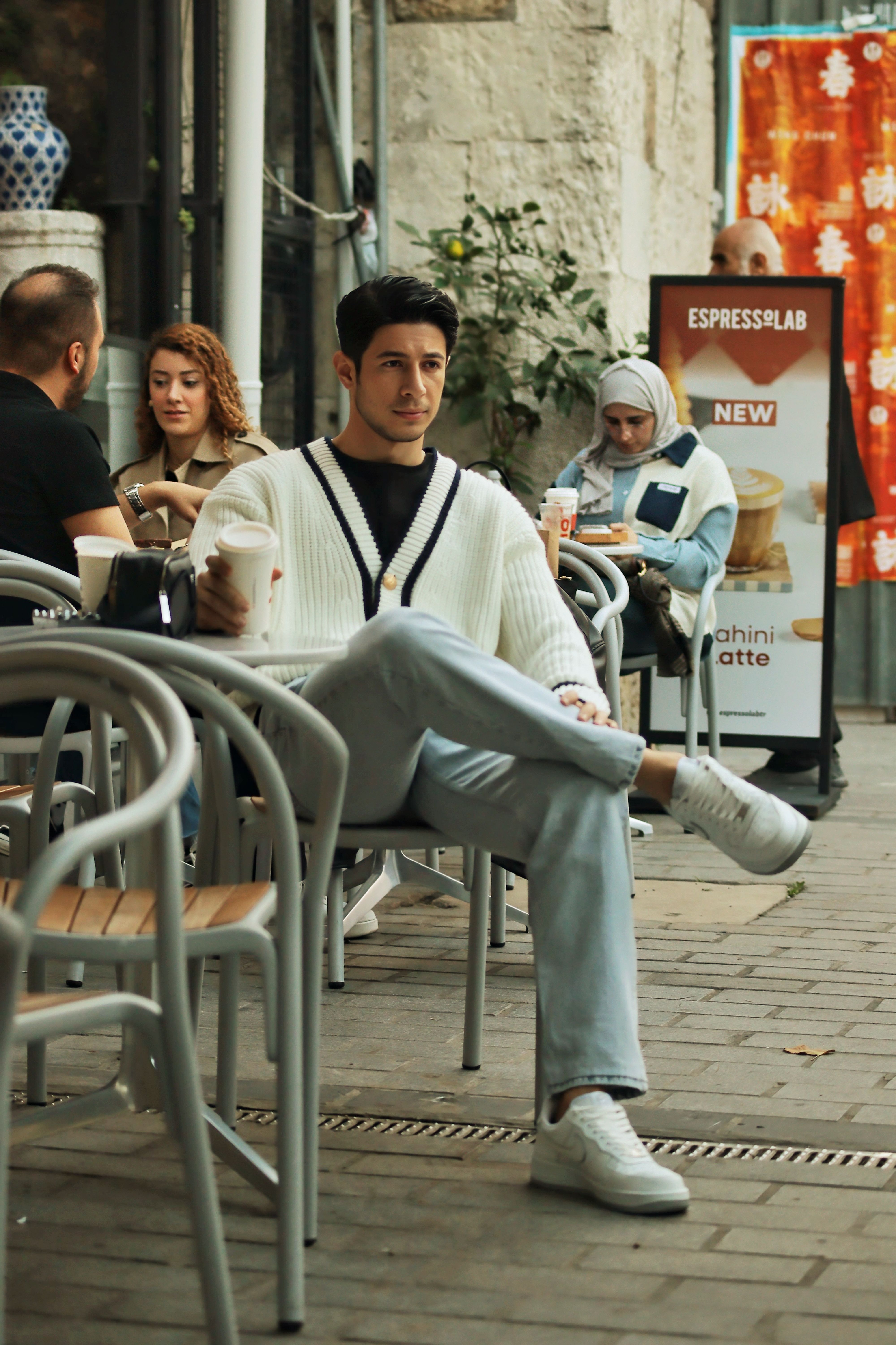 Casual outdoor cafe seating with diverse group enjoying coffee