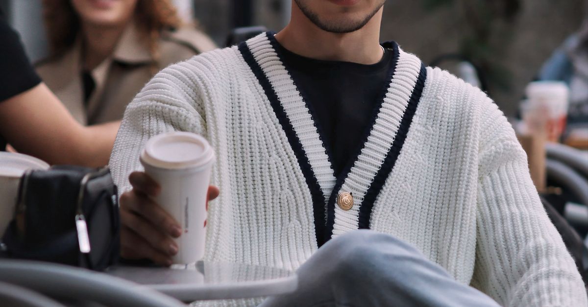 Young adults enjoying coffee at an outdoor cafe, dressed stylishly.