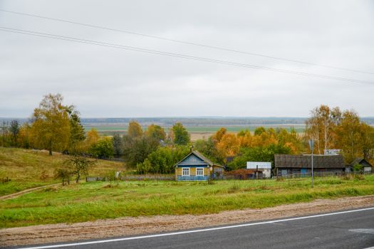 Charming rural landscape in Grodno Region, Belarus, with colorful autumn foliage and a quaint village house.