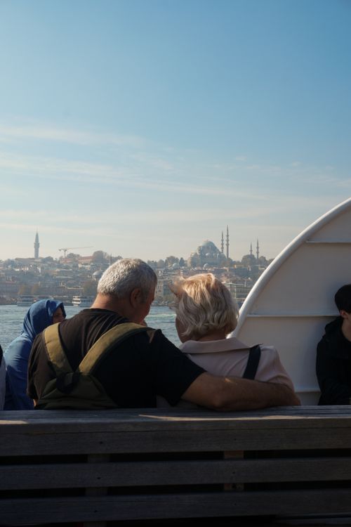 Free A senior couple on a ferry admiring the Istanbul skyline with historic mosques on a sunny day. Stock Photo