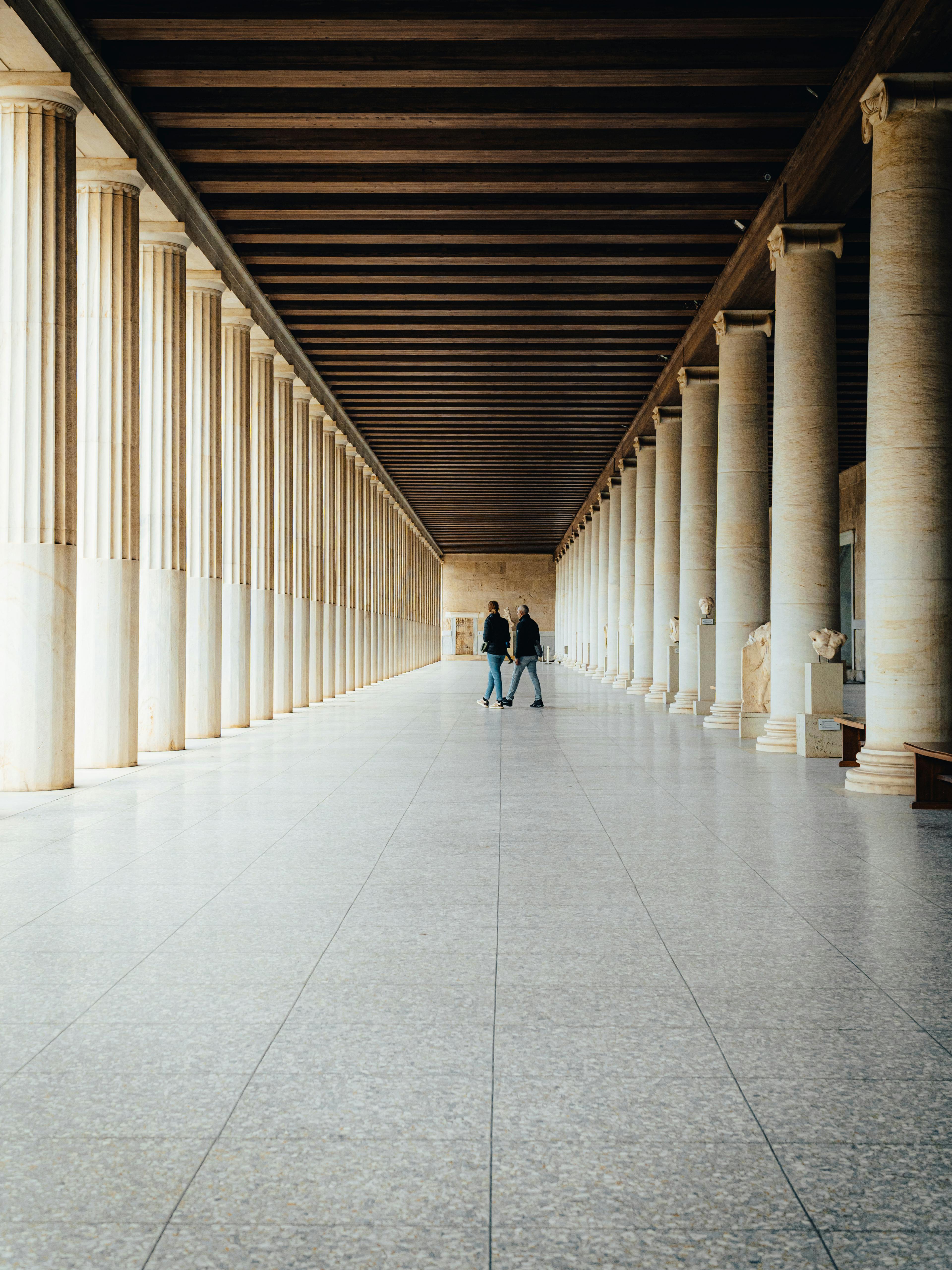 A stunning long corridor with classical columns inside an Athens museum.