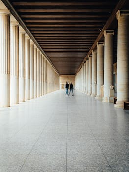 A stunning long corridor with classical columns inside an Athens museum.