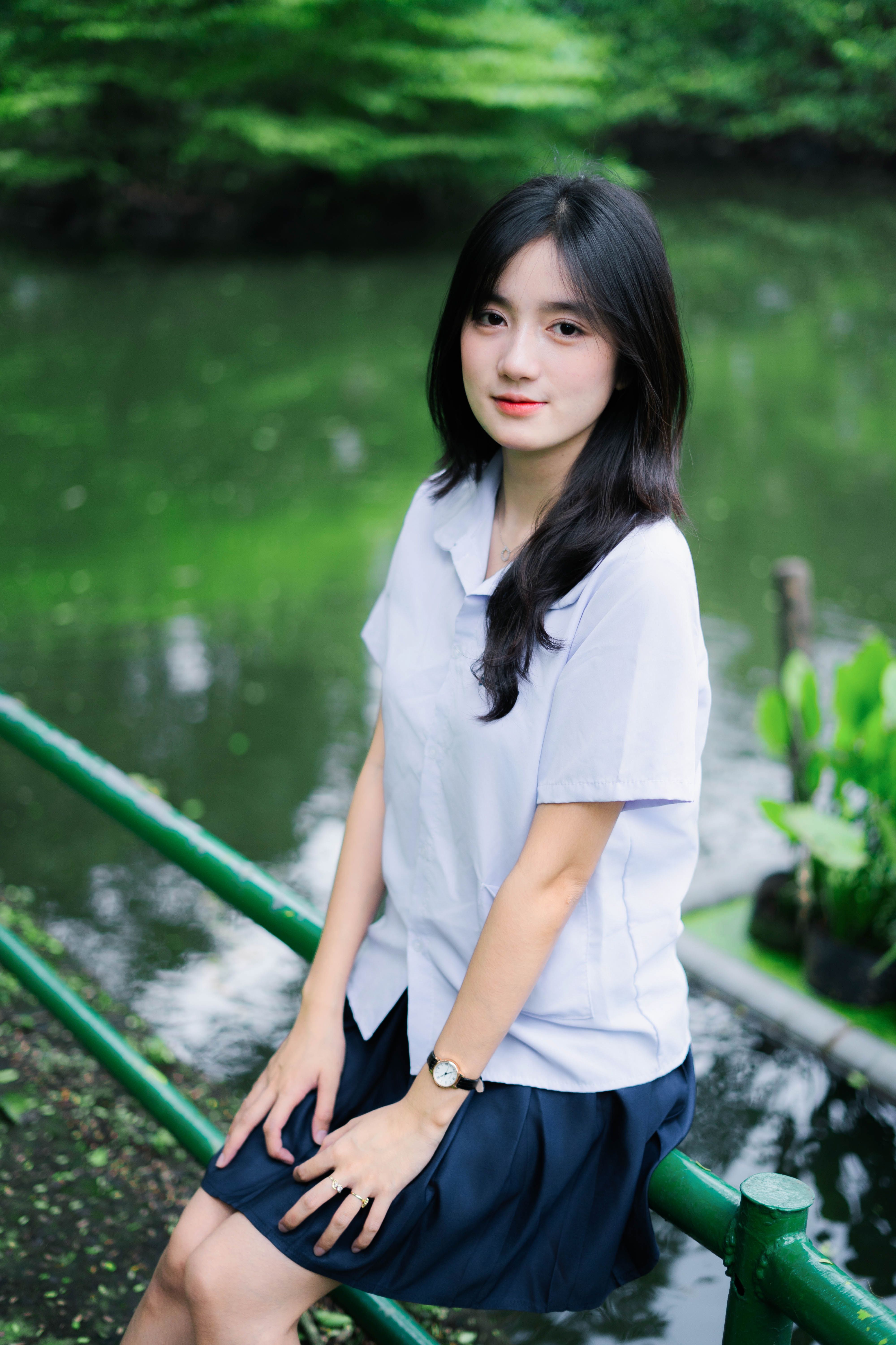 Young Woman in Uniform by Tranquil Pond