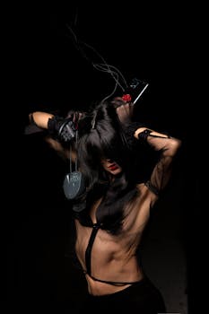 Creative photo of a woman posing with electronics and mesh clothing.