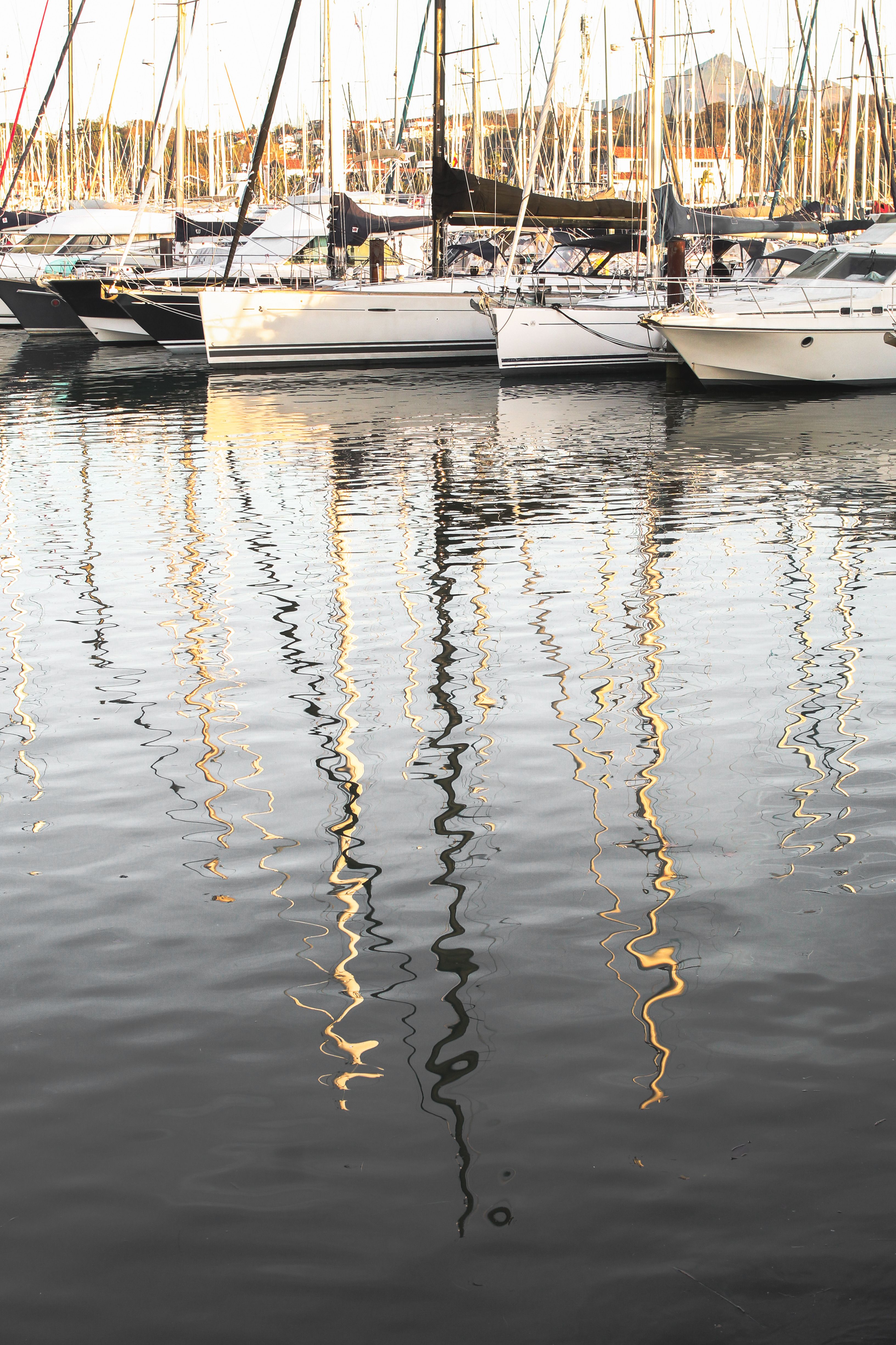 Serene Marina with Sailboat Reflections at Sunset · Free Stock Photo