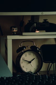 A warm home workspace featuring a vintage alarm clock and figurine, perfect for inspiring creativity.