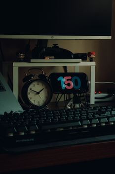A tidy home workspace featuring an analog clock, monitor, and various desk accessories, perfect for organized work from home.
