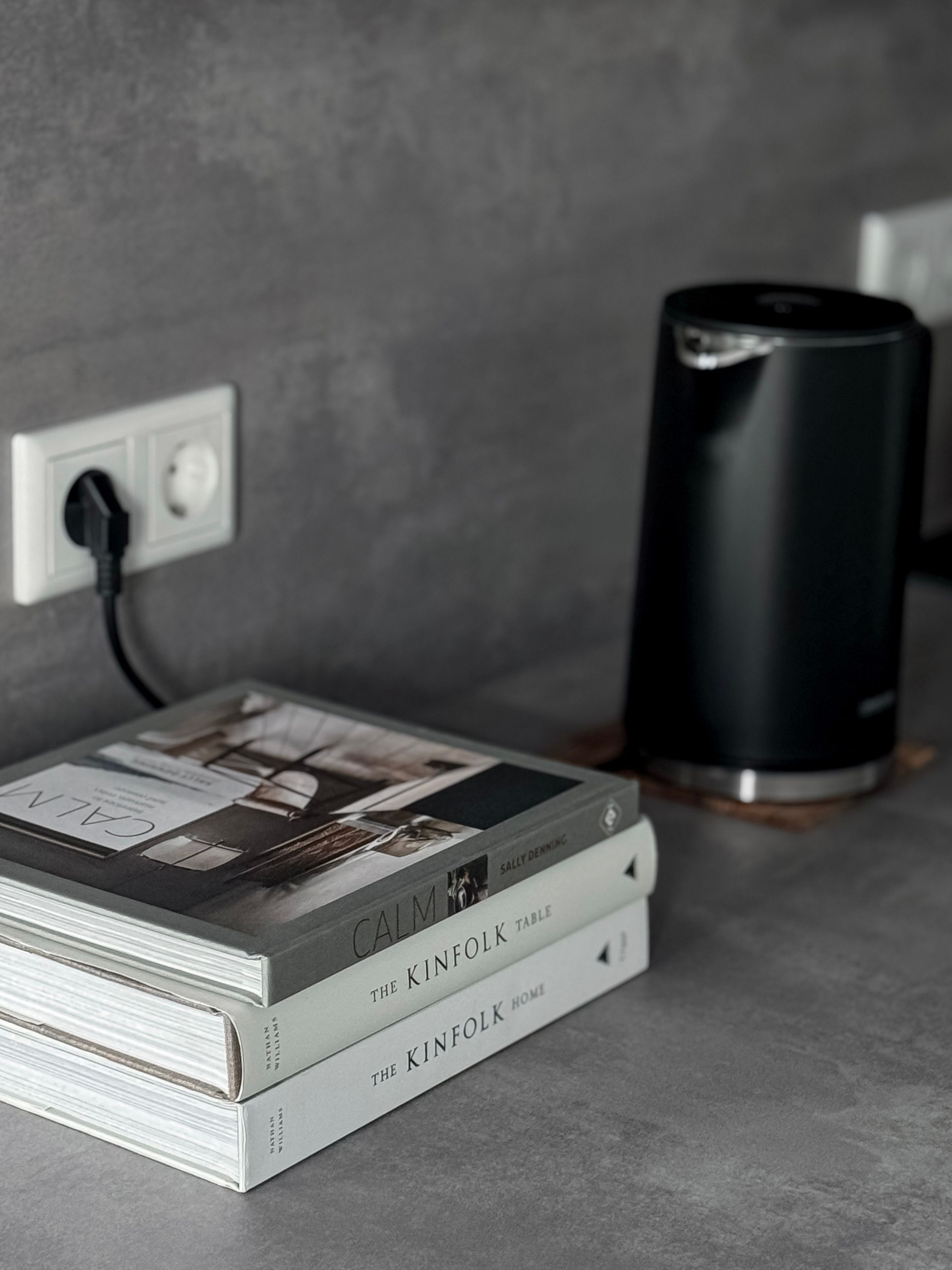 A sleek Berlin kitchen counter with books and a black electric kettle, showcasing modern aesthetics.