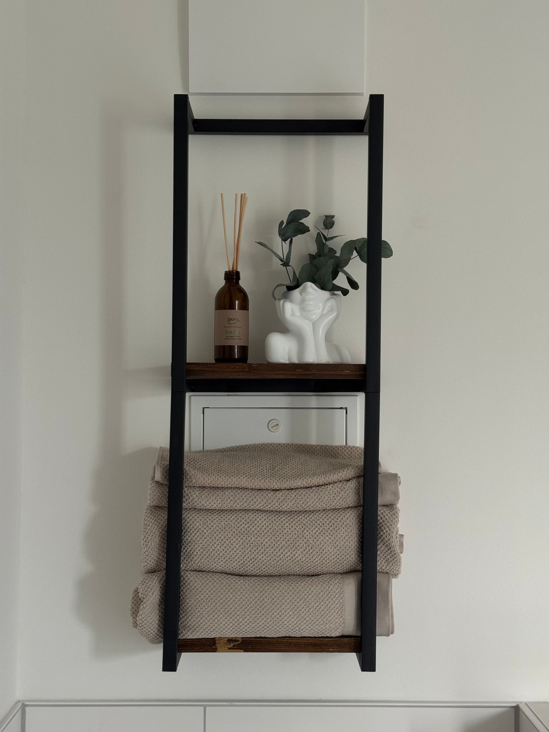 Minimal bathroom shelf with a restrained number of towels and toiletries