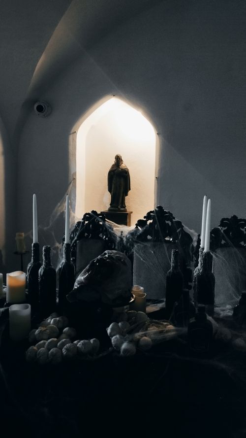 Free Dimly lit gothic altar adorned with candles and religious statues in a mystical ambiance. Stock Photo