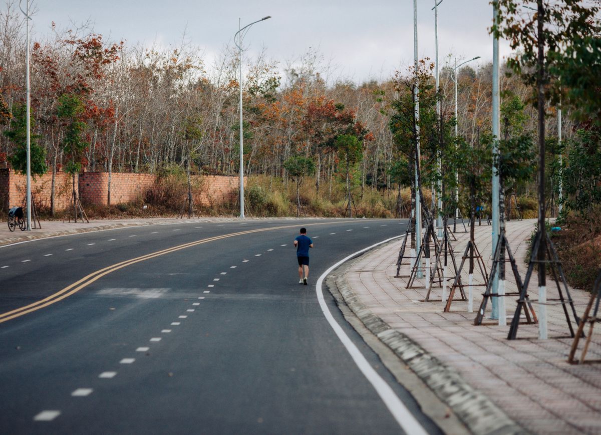 Lone runner on a quiet road at dusk