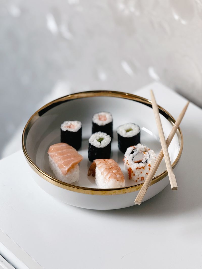 Nigiris au saumon et à la crevette sur une assiette blanche avec des rouleaux
