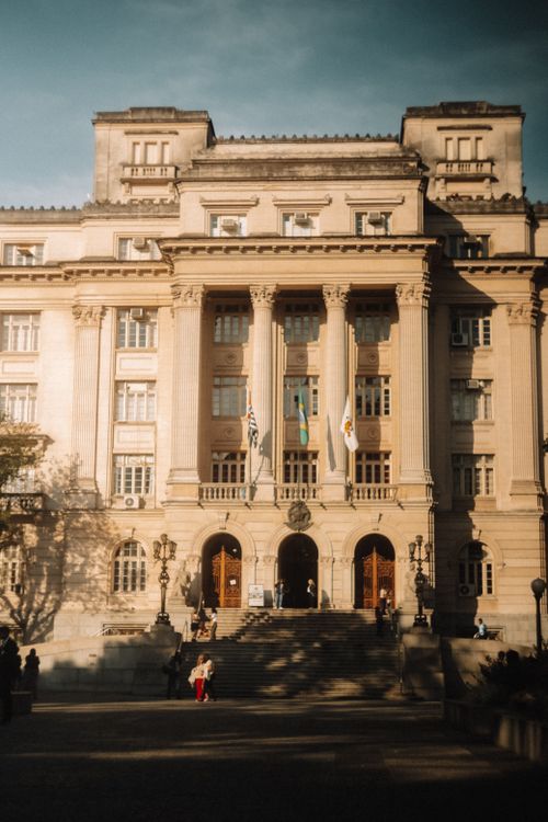Free Elegant historic building with grand columns and flags in urban setting. Stock Photo