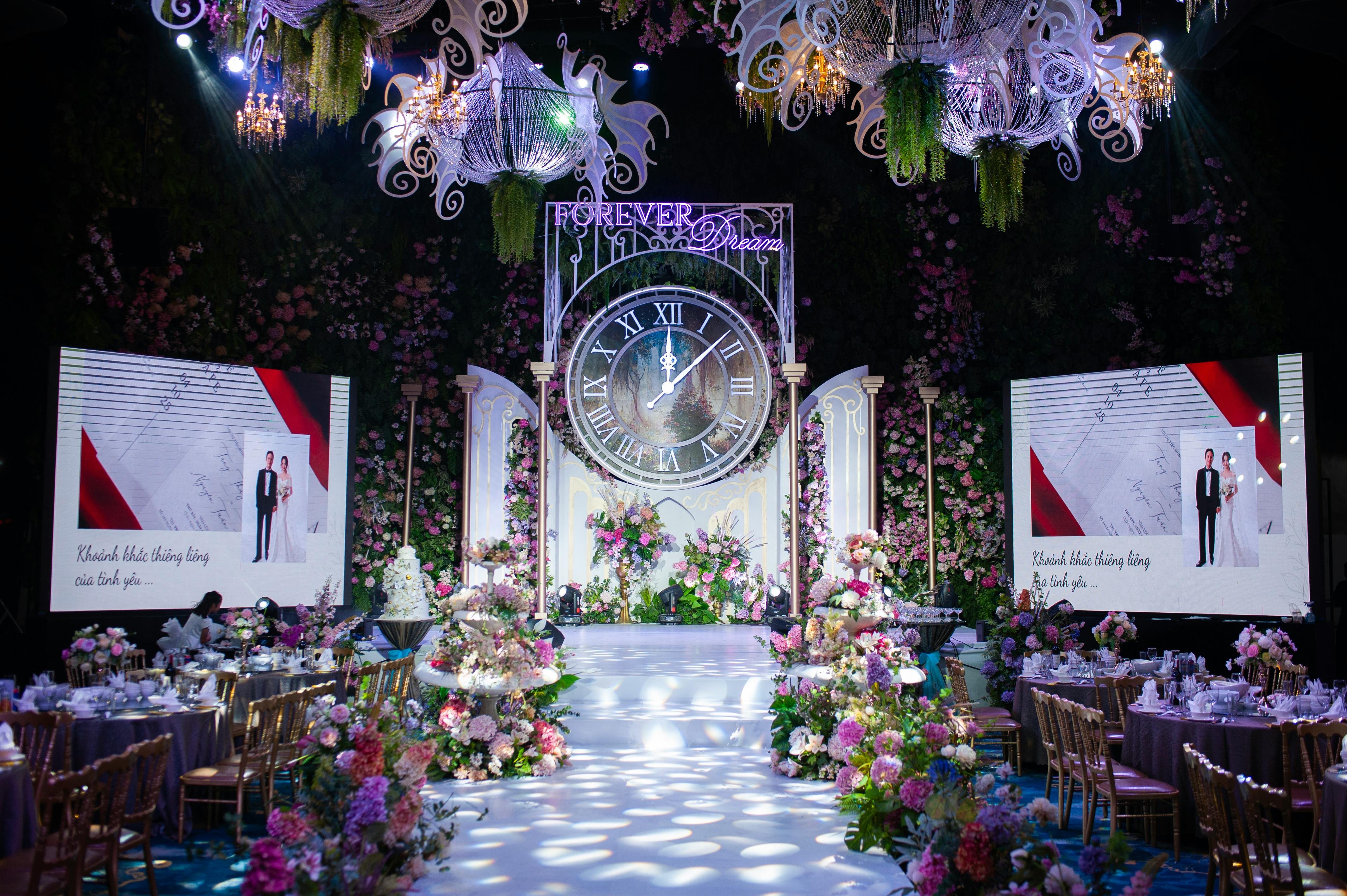 Luxurious wedding hall with ornate floral decorations and large clock centerpiece.