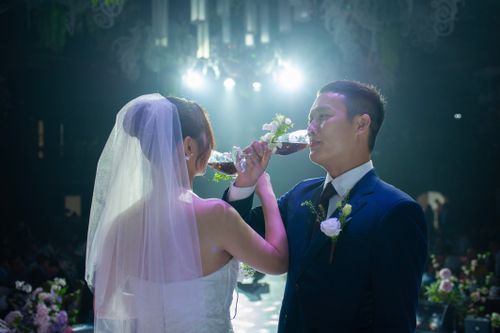 Free Bride and groom share a toast at their wedding, celebrating their union in an elegant ceremony. Stock Photo