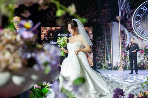 Free Bride in a stunning white gown holding bouquet at beautiful wedding ceremony. Stock Photo