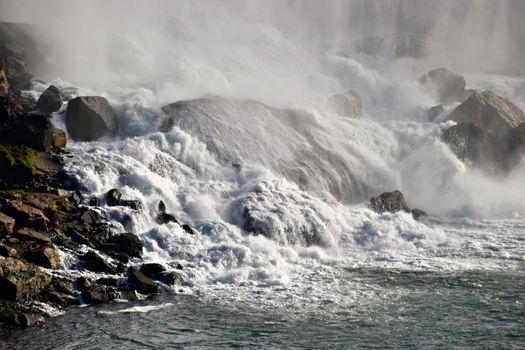 Dramatic view of the roaring waters cascading over rocks at Niagara Falls, Ontario.