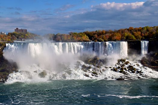 Captivating autumn scene of Niagara Falls with vibrant foliage and cascading waters.