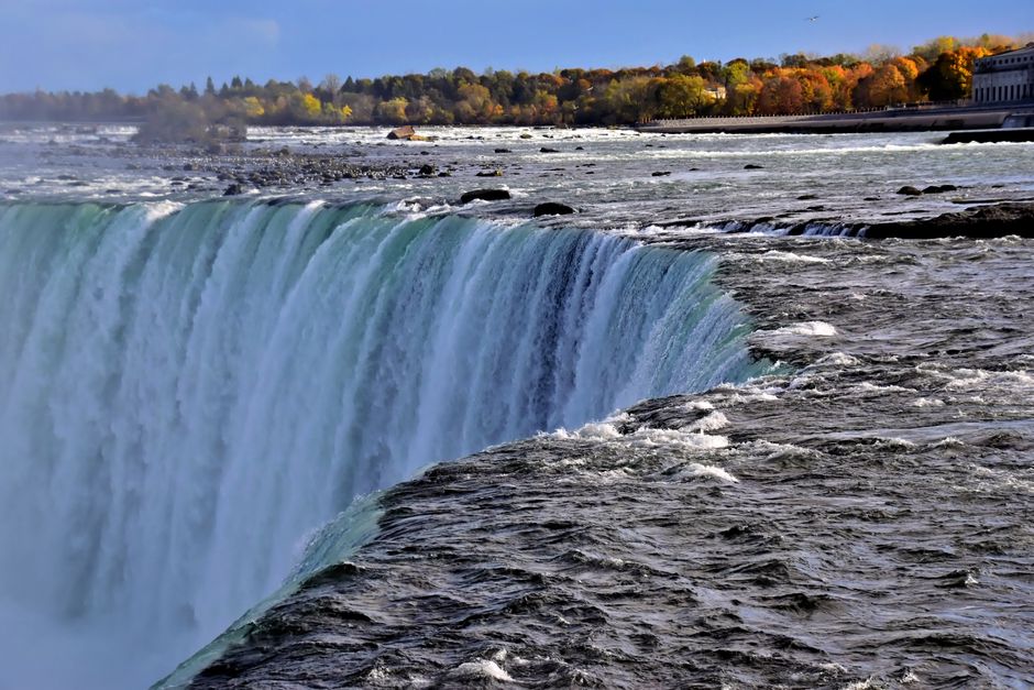 Niagara Falls Canada: Helicopter + Boat + Lunch & more US Pick-up - Stunning view of Niagara Falls with vibrant autumn trees in the background.