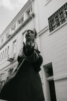 Artistic black and white portrait of a woman on a city street.
