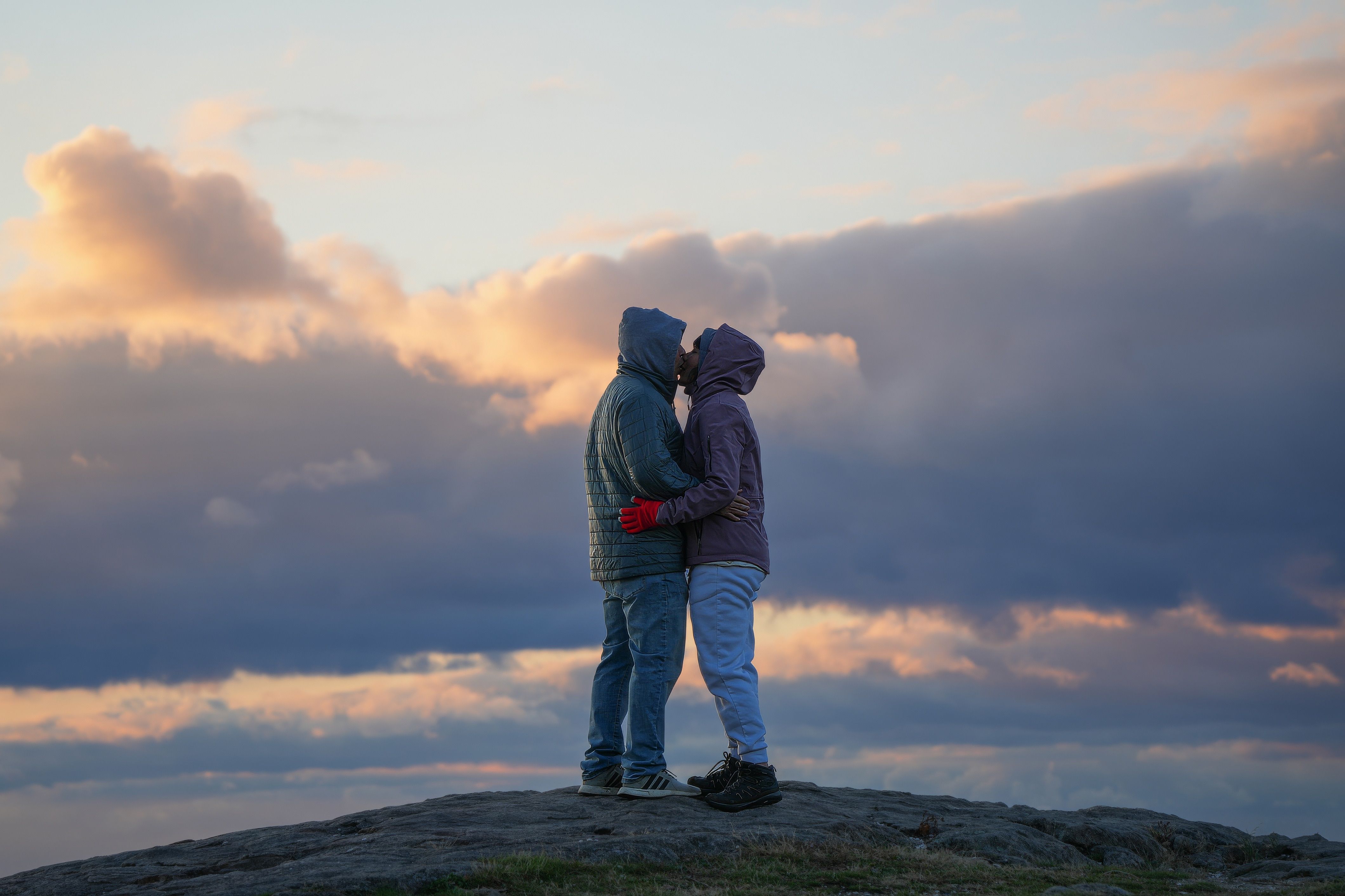 Couple Embracing on Rocky Hill at Sunset · Free Stock Photo