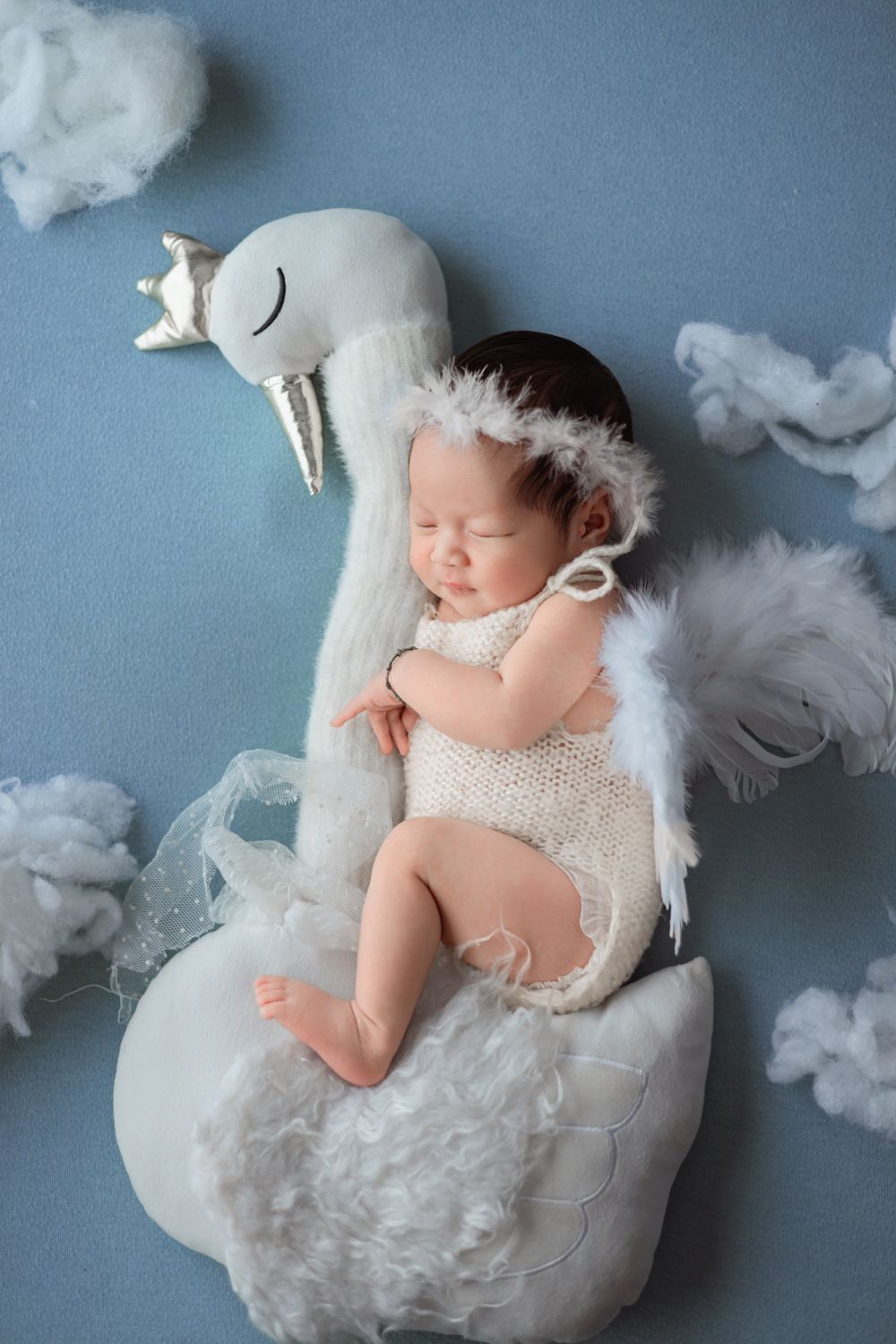 Newborn baby sleeping in an angel costume
