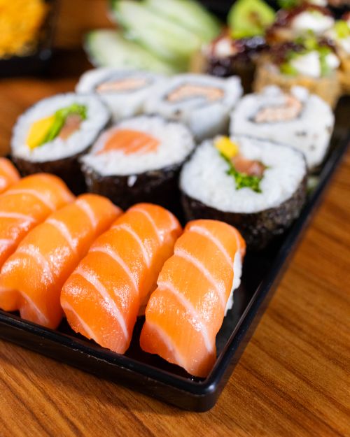 Free A vibrant assortment of sushi featuring fresh salmon nigiri on a wooden table. Stock Photo