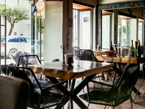 Free Sunlit restaurant interior with elegant tables and chairs, showcasing a welcoming dining atmosphere. Stock Photo
