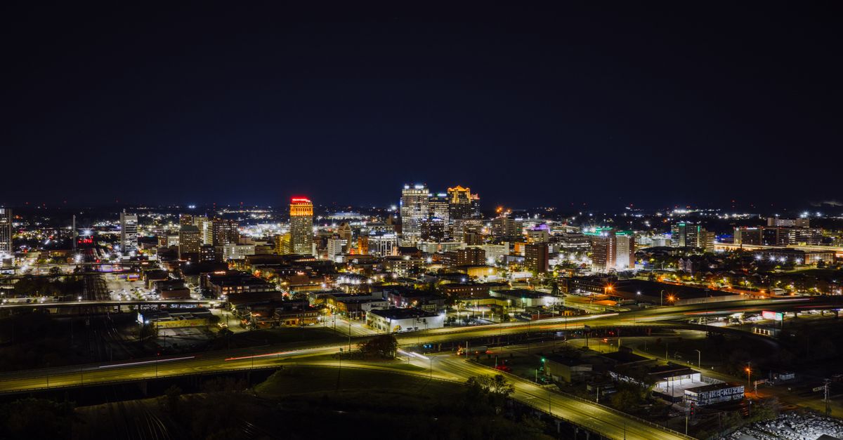 Stunning aerial night view of Birmingham, Alabama skyline with city lights.