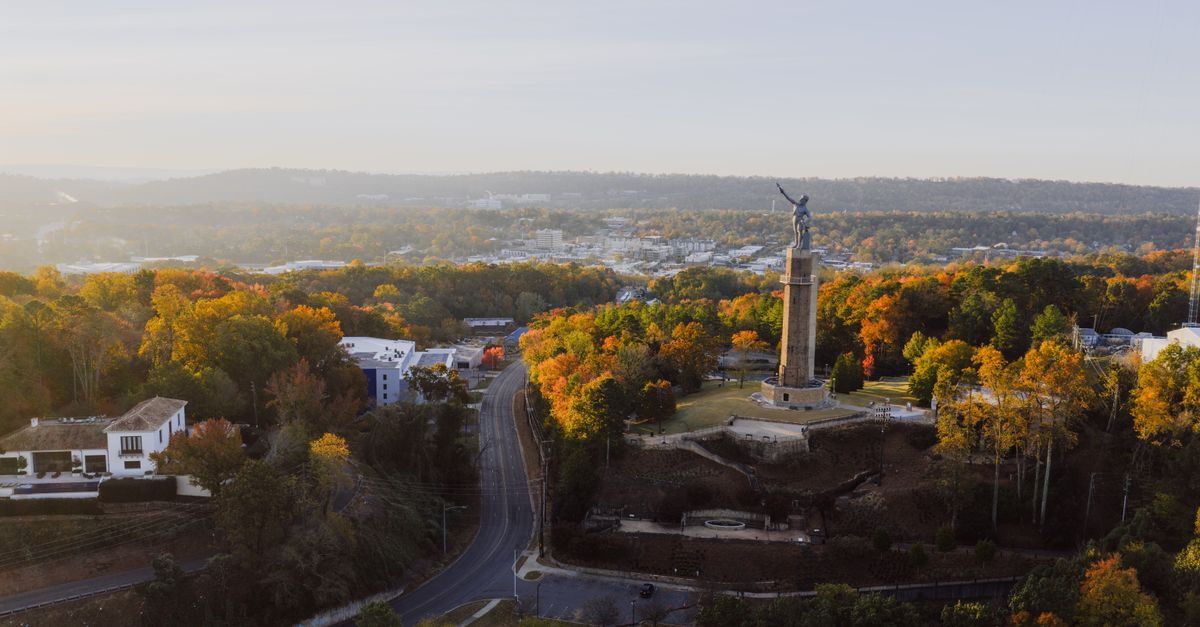Drone view of Vulcan Park and fall foliage in Birmingham, Alabama at sunset.