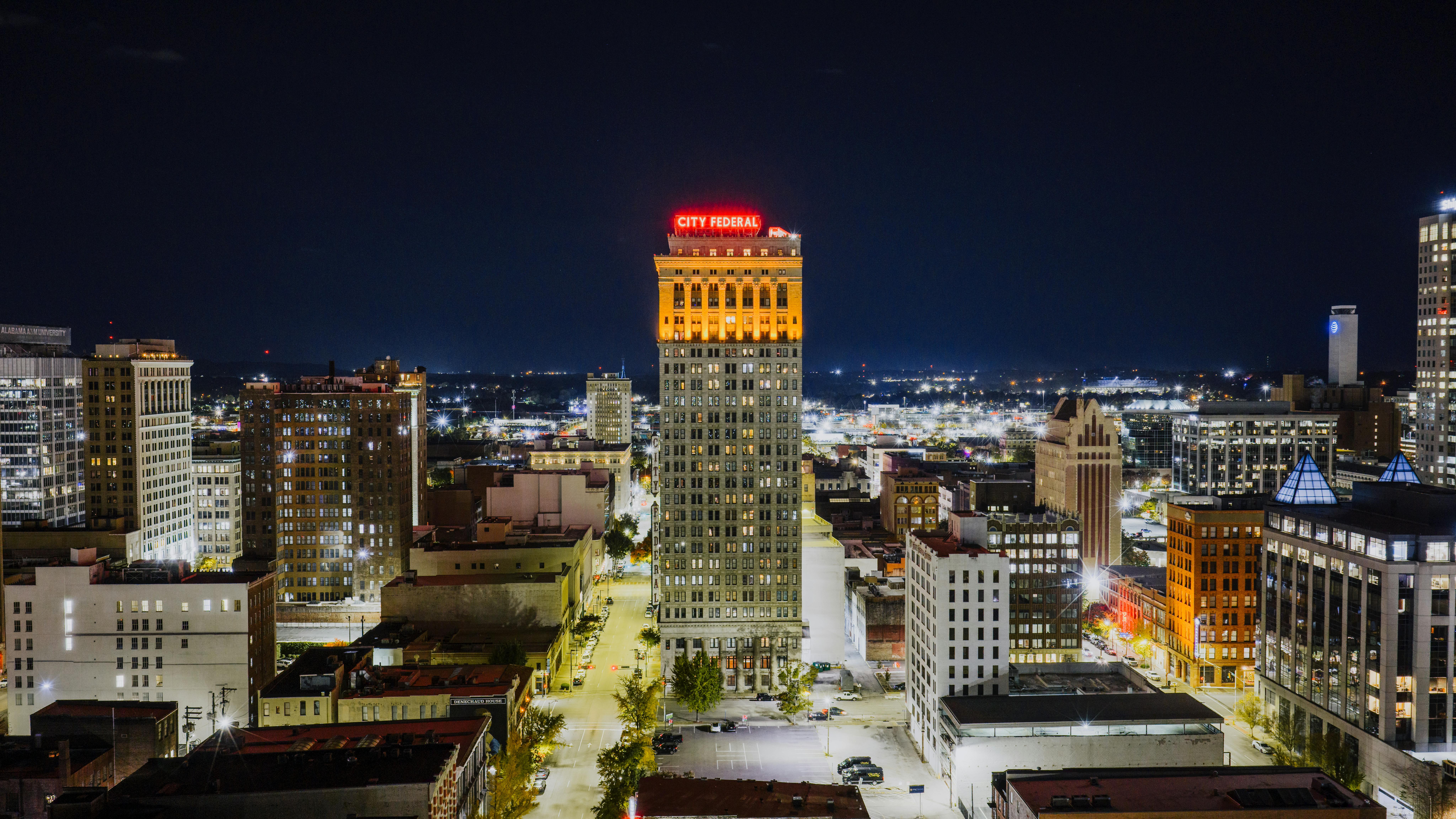 Aerial view of Birmingham's City Federal Building illuminated at night, showcasing urban architecture.