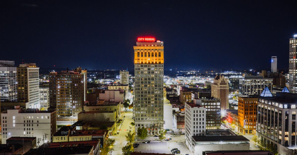 Aerial view of Birmingham's City Federal Building illuminated at night, showcasing urban architecture.