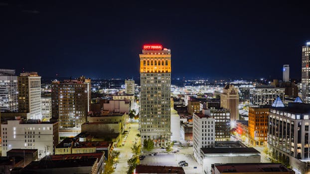 Aerial view of Birmingham's City Federal Building illuminated at night, showcasing urban architecture.