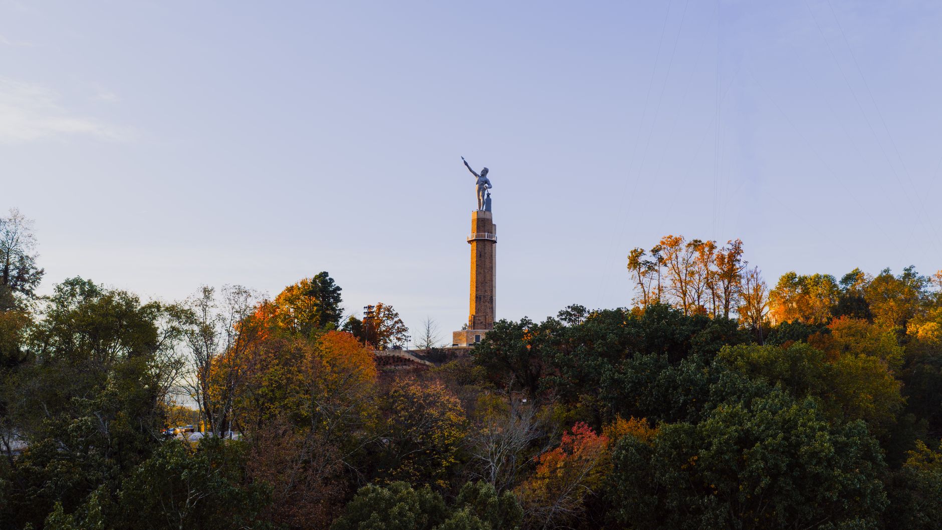 Aerial view of Vulcan Statue surrounded by autumn foliage in Birmingham, Alabama.