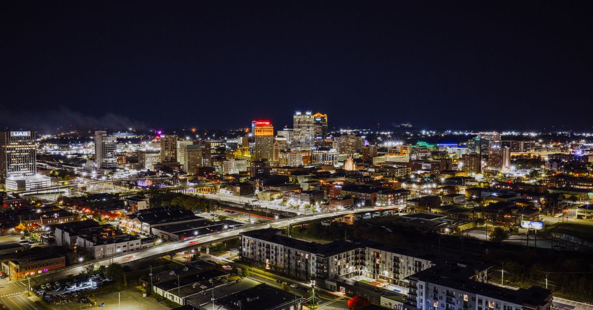 Stunning aerial night view of Birmingham, Alabama with illuminated cityscape and skyscrapers.