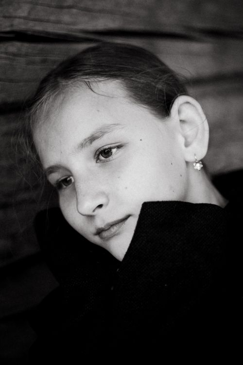 Free A black and white portrait of a young girl with a thoughtful expression. Stock Photo