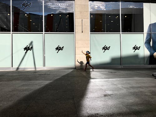 Woman in Yellow Shirt and Black Pants Walking on Sidewalk