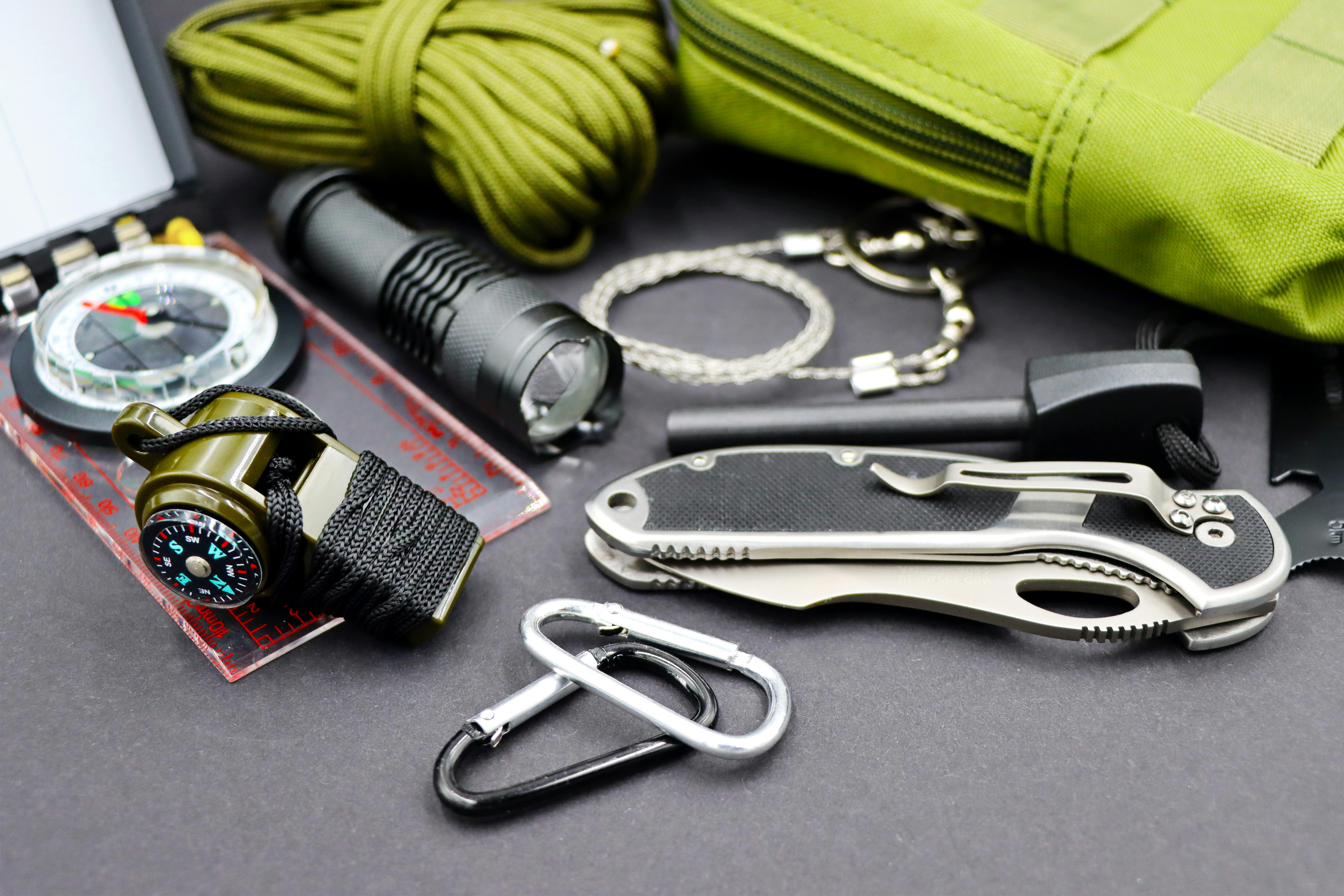 A detailed flat lay of essential survival tools for outdoor adventure and tactical use.