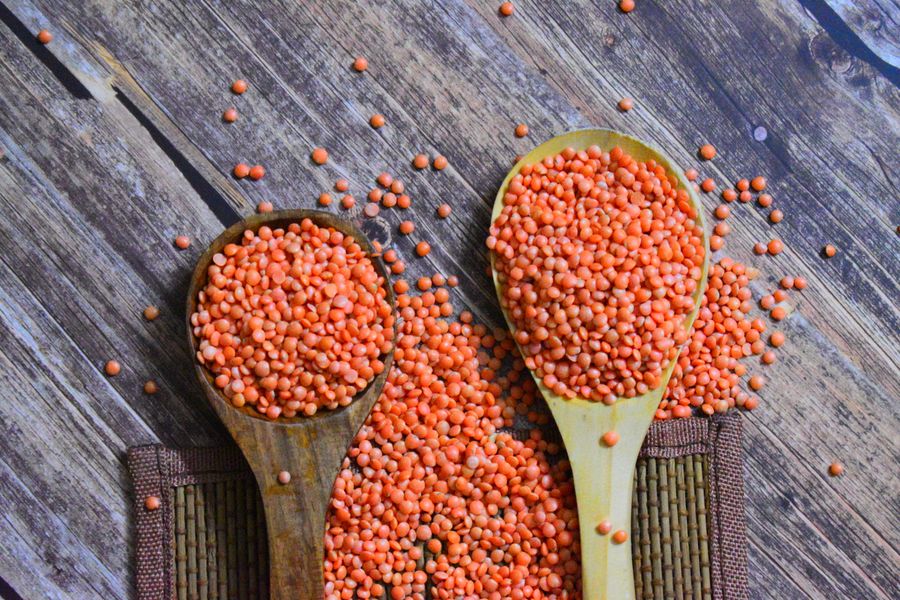 Split red lentils (masoor) on wooden spoons