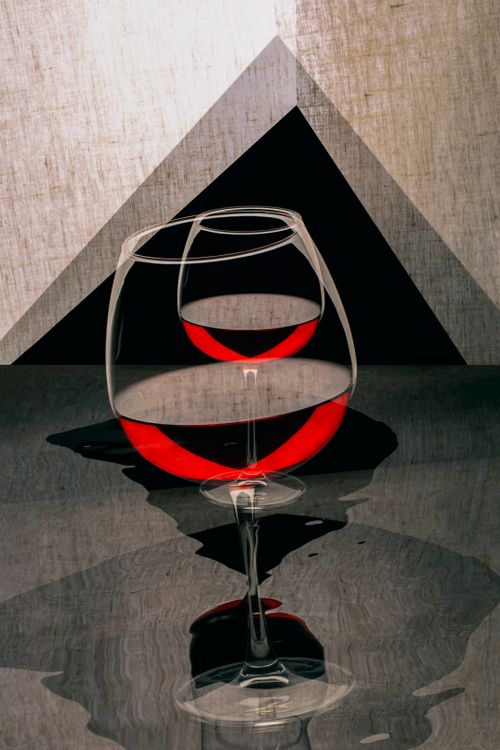 Free Abstract photo of wine glasses with a red liquid reflection, creating a geometric illusion. Stock Photo