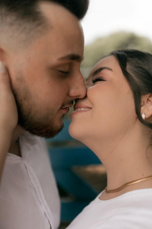 Free Romantic moment of a couple embracing closely, sharing affection outdoors. Stock Photo