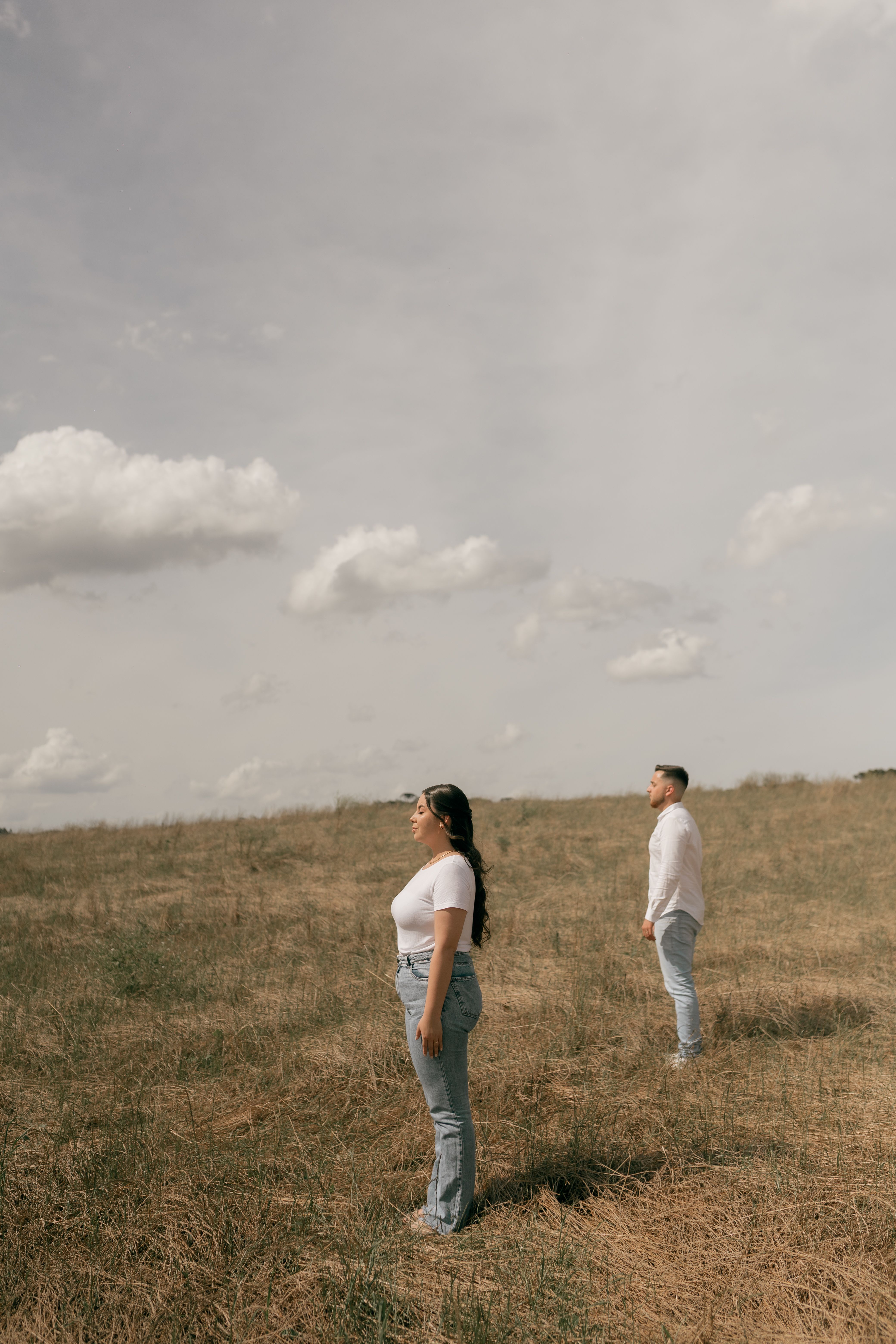 Two Adults Standing in a Field Under Cloudy Sky · Free Stock Photo