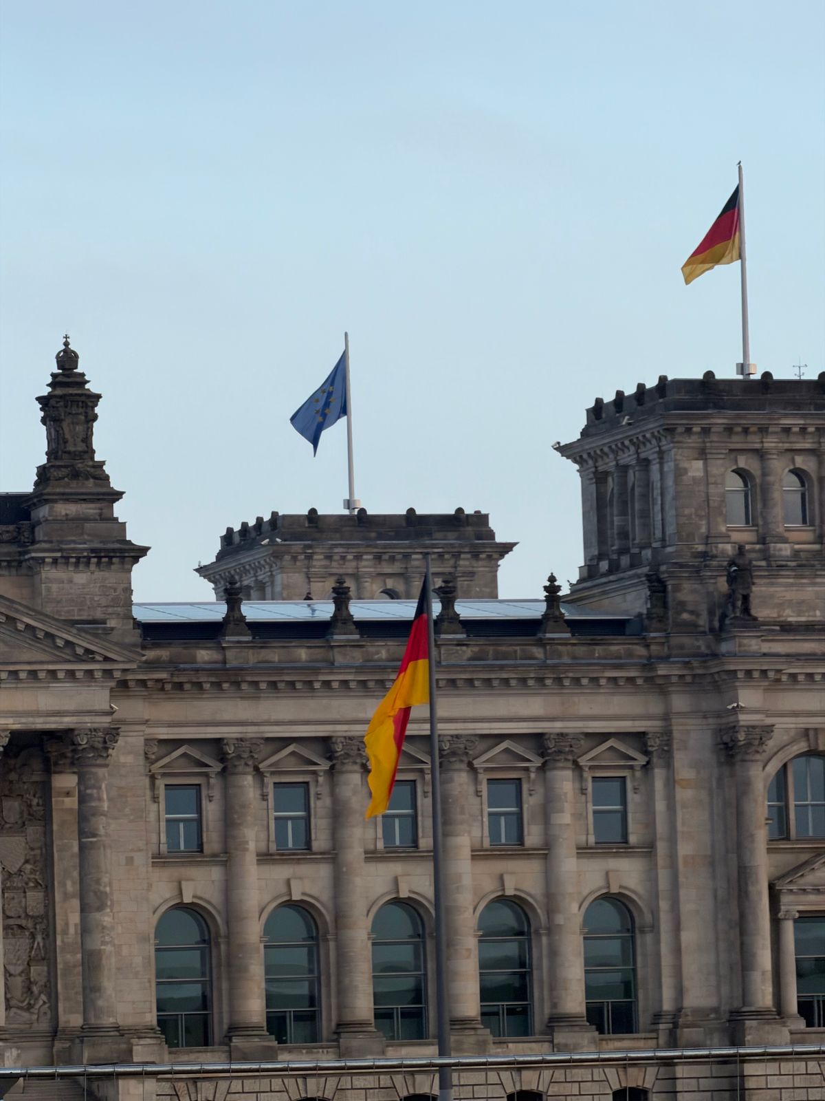Close-up of the Reichstag building in Berlin with German and EU flags, symbolising Germany's skilled worker immigration system