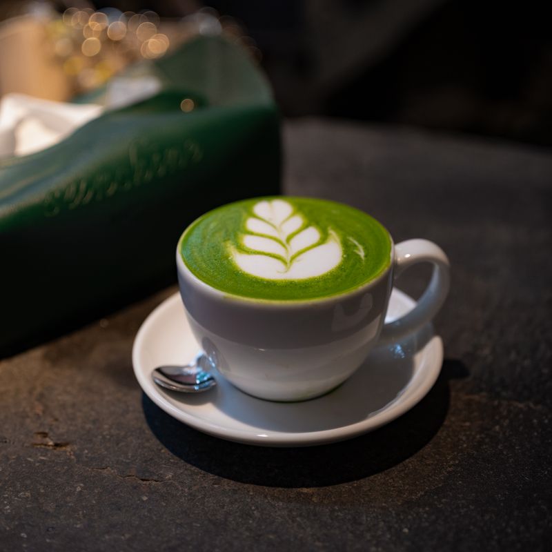 Matcha latte with leaf art in a cup — photo by Lucas Dang on Pexels