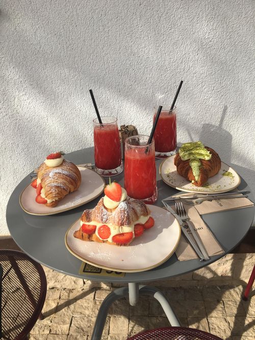 Free Delicious pastries and refreshing drinks on a sunny outdoor table. Stock Photo