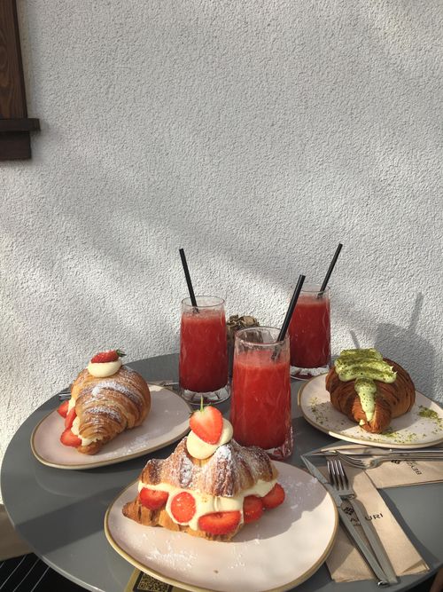 Free A delightful breakfast setting with strawberry croissants and refreshing red juice under sunlight. Stock Photo